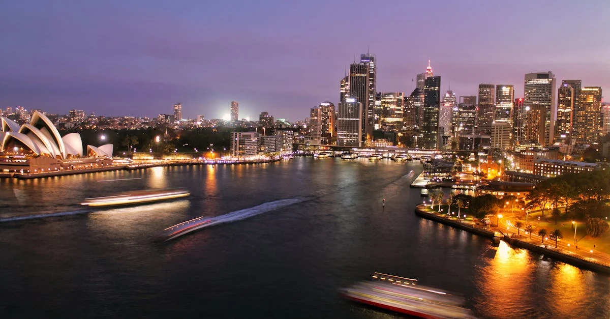 Captivating view of Sydney's illuminated skyline with the iconic Opera House and harbor at night.